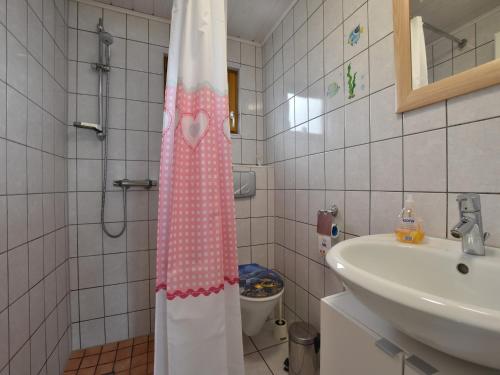 e bagno con tenda per la doccia, servizi igienici e lavandino. di Salzhaff Finca in Pepelow a Pepelow
