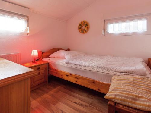 a bedroom with a bed and a table with a lamp at Ruhiger Bungalow am Hennesee mit Terrasse 