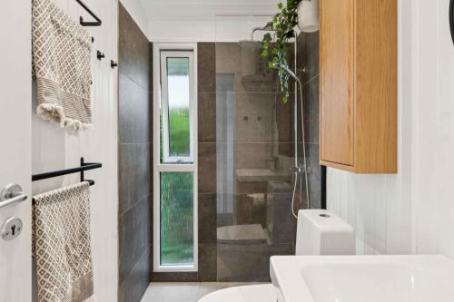 a bathroom with a shower and a toilet and a sink at Lovely Summerhouse By Skaastrup Strand W Sea View in Bogense