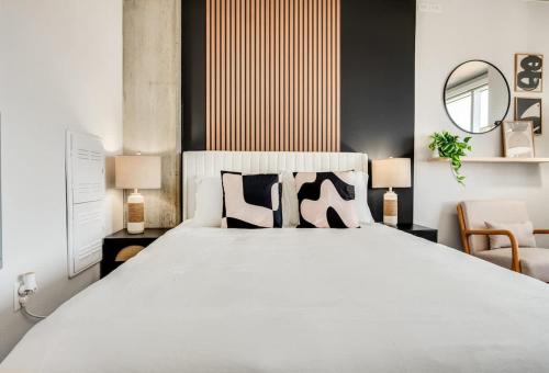 a bedroom with a large white bed and a mirror at Boulevard Stays Downtown Highrise STU Sky Pool Parking Gym 05 in Phoenix