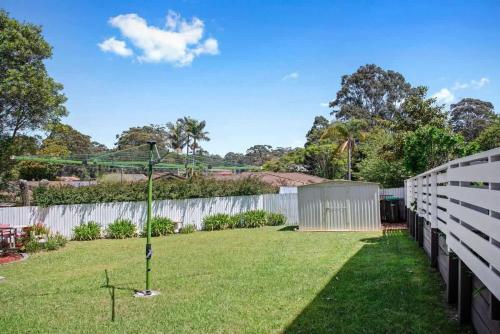 a backyard with a fence and a grass yard at Mollymook Beach Haven - near ocean & golf course in Mollymook