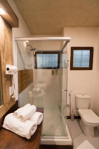 a bathroom with a glass shower and a toilet at Beijo do Vento Pousada in Arraial d'Ajuda