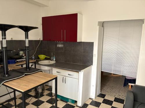 una cocina con gabinetes rojos y una encimera en Le study, en Béziers