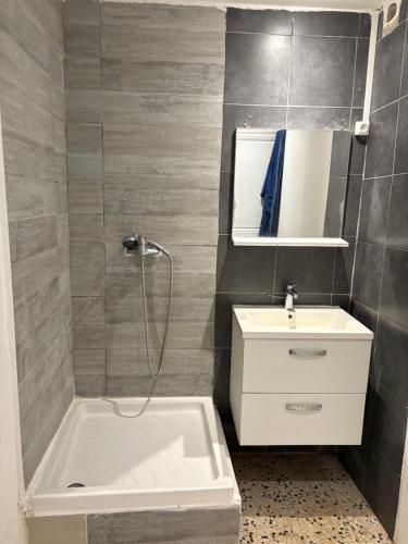 un baño con una bañera blanca y un lavabo en Le study, en Béziers