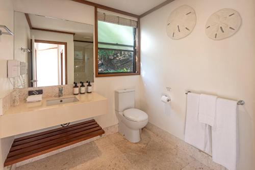 a bathroom with a toilet and a sink and a mirror at Alang Alang on Hamilton Island by HIHA in Hamilton Island