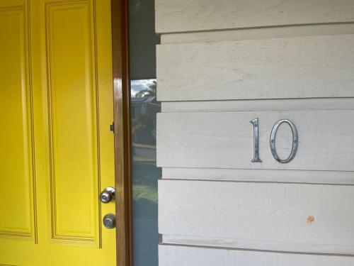 a yellow door with the number on it at The Bawley Hideaway in Bawley Point