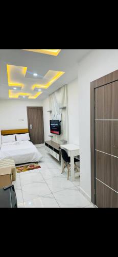 a bedroom with a bed and a desk and a television at NgoZiLiving in Lekki