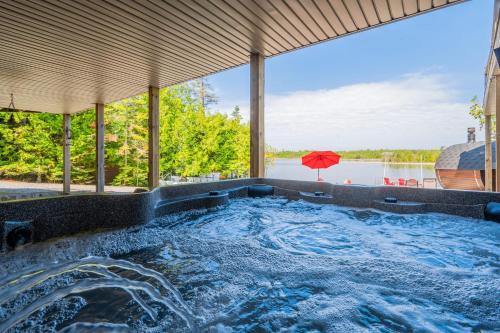 an outdoor hot tub with a view of the water at Waterfront w sauna, hot tub and boat slip in Miller Lake