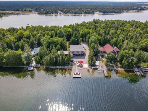 an island with a house and a boat in the water at Waterfront w sauna, hot tub and boat slip in Miller Lake
