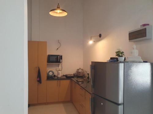 Una cocina con refrigerador de acero inoxidable y microondas. en Cinnamon Holiday Home Near Airport, en Ekala
