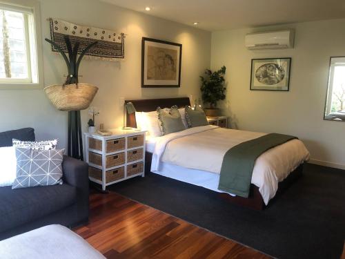 a bedroom with a large bed and a couch at Sweet As Suite in Auckland