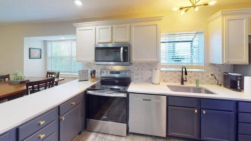 a kitchen with white cabinets and a stove top oven at Beautiful Condo, Steps From Table Rock Lake & Sdc in Branson
