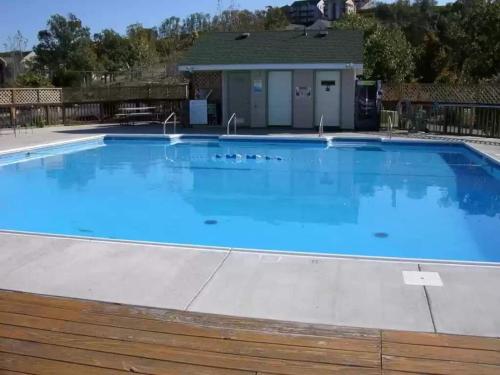 a large swimming pool with blue water at Beautiful Condo, Steps From Table Rock Lake & Sdc in Branson
