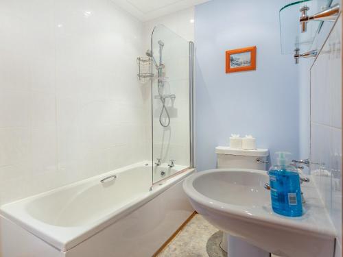 a white bathroom with a tub and a sink at Bidean Lodge in Glencoe