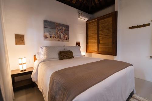 a bedroom with a large bed and a window at Beijo do Vento Pousada in Arraial d'Ajuda