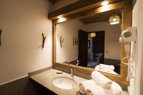 a bathroom with a sink and a large mirror at Beijo do Vento Pousada in Arraial d'Ajuda