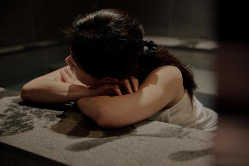 a young girl is sitting on a counter with her head in her hands at Sowon Ryokan and Hotel by Aank Sangbong in Seoul