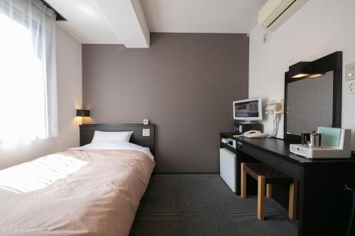 a hotel room with a bed and a desk at クレドホテル臼杵 in Usuki