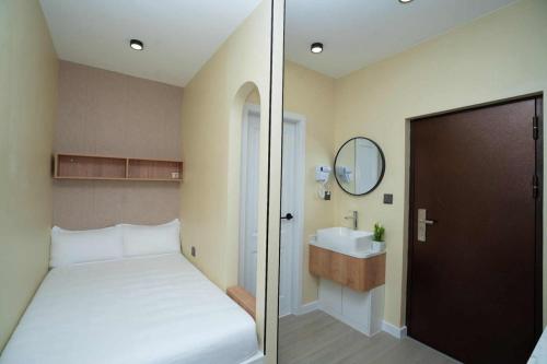 a bedroom with a bed and a sink and a mirror at Monastery Hotel in Ulaanbaatar