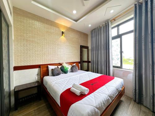 Un dormitorio con una cama grande con una manta roja. en Khách Sạn Hoàng Thanh Thủy 4, en Ho Chi Minh