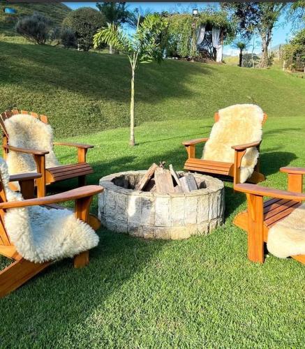 two benches and a fire pit in a park at Fazenda Montanhes in Visconde De Maua