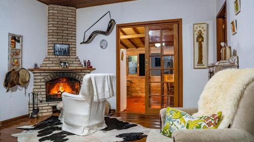 a living room with a fireplace and a couch at Fazenda Montanhes in Visconde De Maua