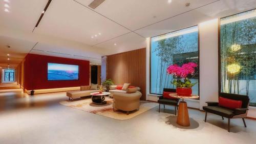 a living room with a couch and a tv at 上海浦东机场华美达安可酒店-免费提供24小时浦东机场班车十分钟到达候机楼出发层 in Shanghai