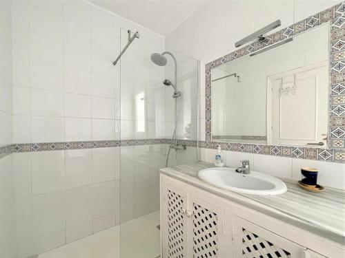 ein weißes Badezimmer mit Waschbecken und Spiegel in der Unterkunft Golf & Beachside Getaway in Roquetas de Mar