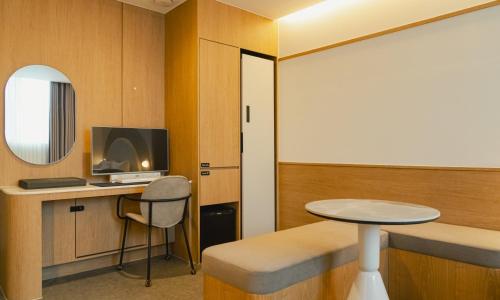 a room with a desk and a table and a chair at Brown Dot Hotel Andong Taehwa in Andong