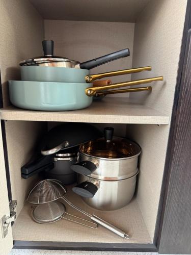 a shelf with pots and pans and utensils in a kitchen at New Spacious 4 bedrooms Family Villa with Skyline View in Panjadakan