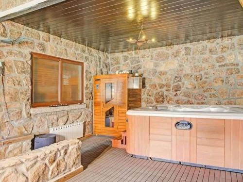 a stone bathroom with a tub and a sink at Farmhouse Apartment with Pool in Galapagar