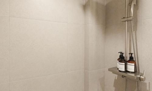 a bathroom with two bottles of alcohol on a shelf at Brown Dot Hotel Andong Taehwa in Andong