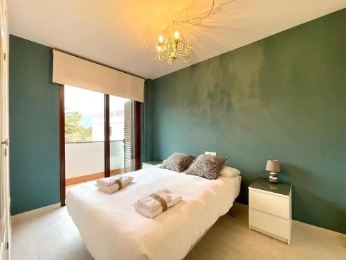 a bedroom with a white bed with a green wall at Sunlit Villa near Golf in Motril