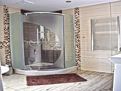 a bathroom with a shower with a round mirror at Holiday Home by Lake in Nowa Wioska in Lubrza