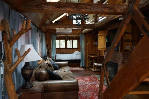 un salon avec un canapé et un lit dans l'établissement Idyllcottage Historic In-town, Hottub, Ac, Dog Ok, à Idyllwild