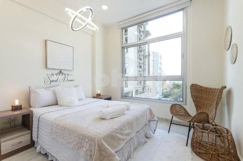 Una habitación blanca con una cama y una ventana en Spacious 2 Bedroom Apartment In Villa Morra, en Asunción