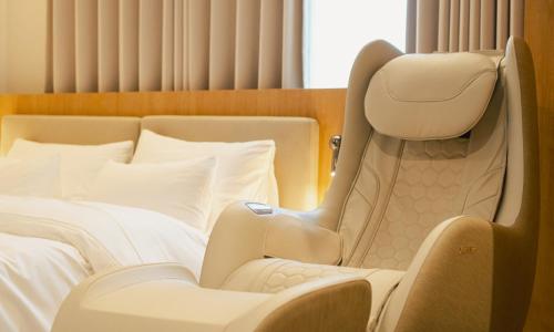 a hotel room with a bed and a chair at Brown Dot Hotel Andong Taehwa in Andong