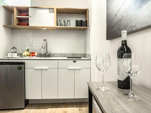 a kitchen with two wine glasses on a table at Cute Quiet Studio, Smart Tv, Six Flags 1 Km in Mexico City