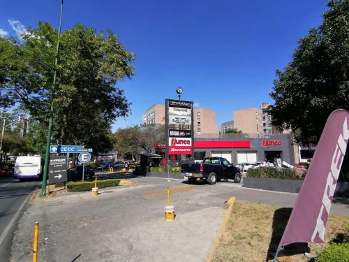 a parking lot with a truck parked in front of a store at Cute Quiet Studio, Smart Tv, Six Flags 1 Km in Mexico City