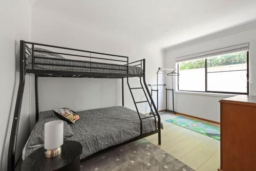 a bedroom with two bunk beds and a window at Barker Retreat in Burrill Lake