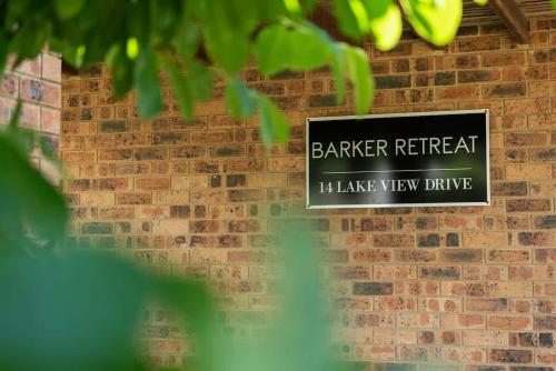 a sign on the side of a brick wall at Barker Retreat in Burrill Lake