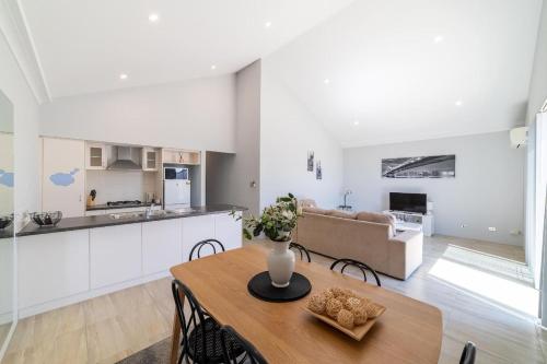 a kitchen and living room with a table and a couch at Swan Valley Fantastic Family Home - Aveley in Henley Brook