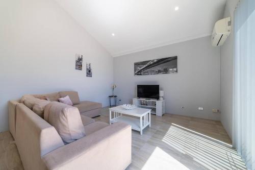 a living room with a couch and a tv at Swan Valley Fantastic Family Home - Aveley in Henley Brook