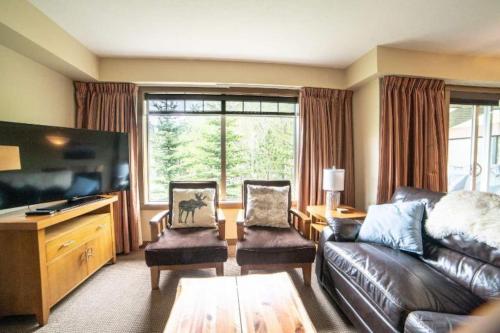 a living room with a couch and a flat screen tv at Hidden Gem 3br King Beds-bbq-hot Tub-pets Ok in Dead Man's Flats