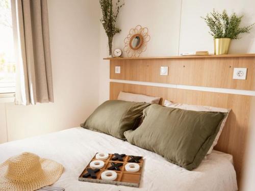 a bed with a tray of donuts on it at Mobil home 6 pers avec terrasse, 3 chambres - API-1-52-651 in Saint-Maurice-dʼIbie