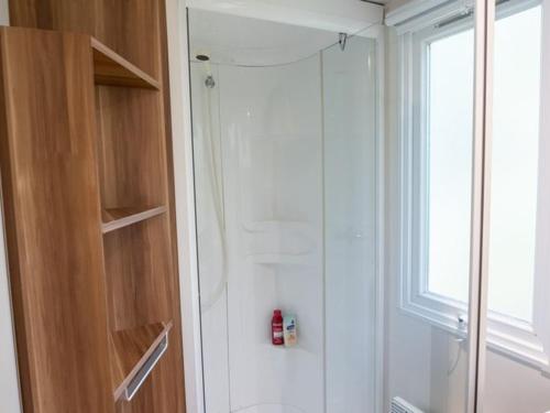 a bathroom with a shower with a glass door at Mobil home moderne avec terrasse pour 4 personnes - API-1-52-468 in Granges-Aumontzey