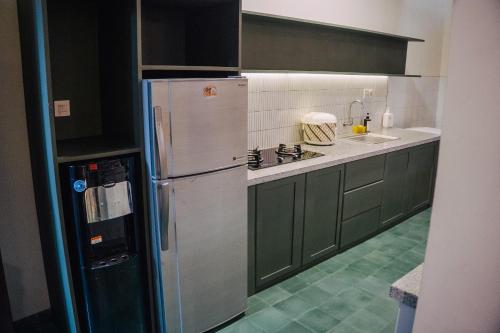 eine Küche mit Kühlschrank und Spüle in der Unterkunft Guesthouse Syariah Griya Truntum in Lawean
