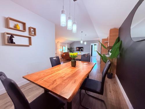 a dining room with a wooden table and black chairs at Le Central Fonctionnel Confort - 2CH in Quebec City