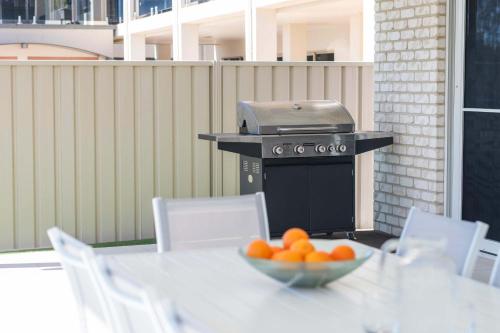un bol d'oranges sur une table avec un gril dans l'établissement Stillwater Stay - Oceanstays - Jetty, à Yamba