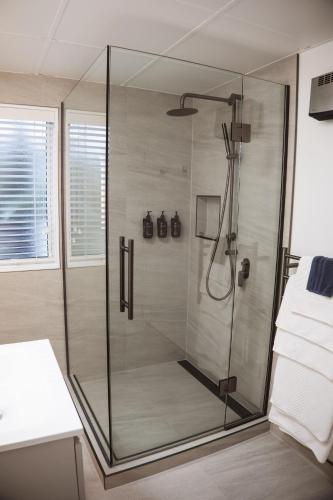 a shower with a glass door in a bathroom at Radfords on the Lake in Te Anau
